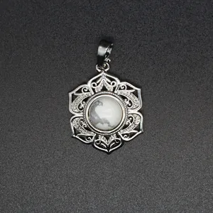 Vue macro d'un pendentif floral en argent avec une pierre blanche