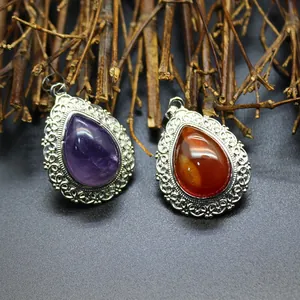 Close-up view of teardrop natural amethyst and agate pendants with vintage filigree borders.