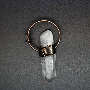 Close-up detail of a natural raw crystal point pendant with vintage copper wire wrap