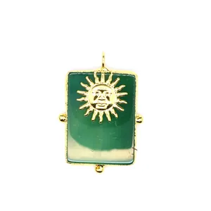 Détail d'un pendentif rectangulaire en agate verte avec un visage de soleil d'or.