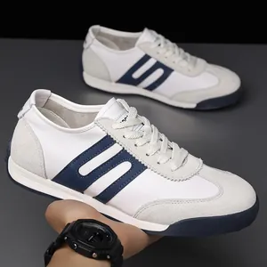Detailed view of men's retro trainers featuring white leather and blue suede patchwork.