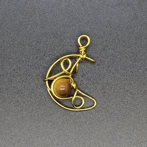Close-up of handmade wire-wrapped crescent moon pendant with natural tiger eye stone