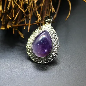 Detailed view of teardrop-shaped amethyst pendant with an intricate silver filigree border
