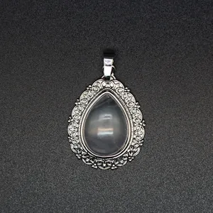 Close-up view of the intricate silver floral engraving on the teardrop pendant frame
