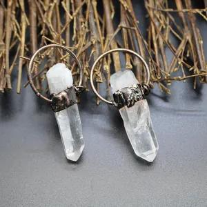 Detail view of natural raw clear crystal point pendants with rustic metal rings