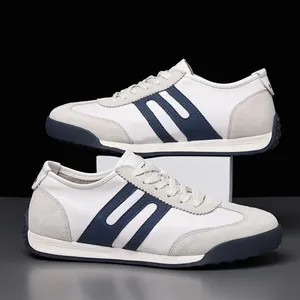 Close-up of stylish white leather men's sneakers with navy blue stripes and suede details.