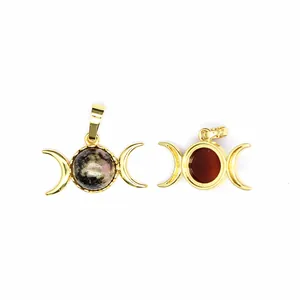 Detailed macro view of 24K gold plated triple moon goddess pendants with semi-precious stones