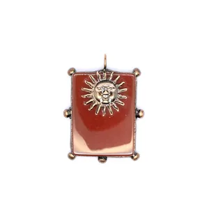 Vue détaillée d'un pendentif rectangulaire en agate rouge avec motif soleil