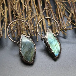 Detailed view of raw labradorite pendants with rustic bronze metal wrap and blue sheen.