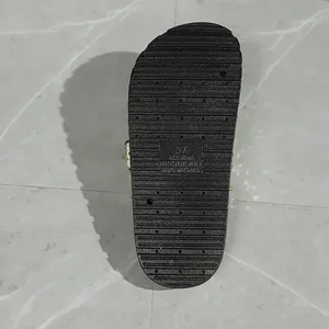 Close-up of a black textured slipper sole showing anti-slip pattern and size marking