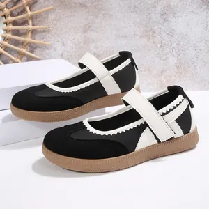 Vista dettagliata delle scarpe basse Mary Jane bianche e nere con cinturino a strappo