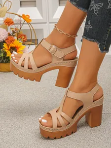 Detailopname van beige platformsandalen met bandjes en dikke houten hakken