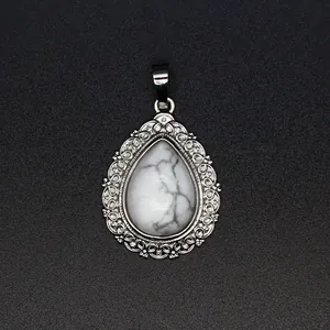 Detailed view of teardrop pendant with white howlite stone and silver filigree border.