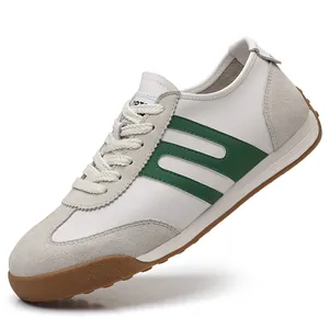 Side view detail of stylish white men's sneakers with green stripes and durable gum sole