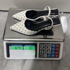 Tacón destalonado con lunares blancos pesando 0,290 kg en una báscula digital de precisión