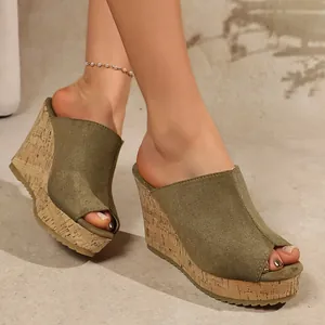 Detailed view of women's olive green suede peep-toe wedge sandals with cork platform heel