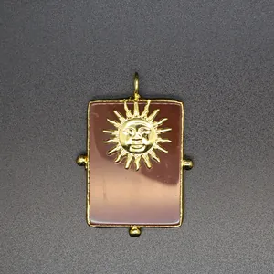 Détail d'un grand pendentif soleil doré avec une base en pierre naturelle brune élégante.