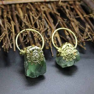 Close-up of golden sunflower charms on natural green labradorite raw stone pendants