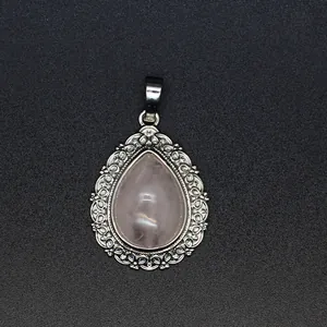 Detailed macro of a teardrop pink crystal pendant with decorative silver filigree