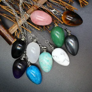 Variety of egg-shaped natural stone pendants on silver chains for dowsing and jewelry.
