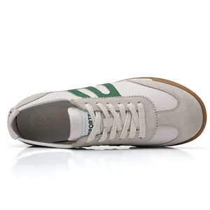 Top view of premium men's white vintage GAT sneakers with green stripes and gum sole