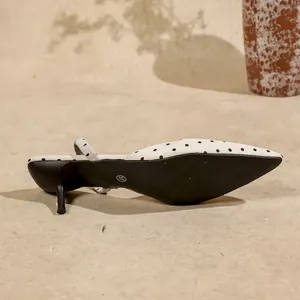 Primer plano de sandalias de lunares con tacón de gatito mostrando la suela.