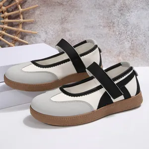 Primo piano di comode ballerine Mary Jane con cinturino in velcro e suola in gomma.