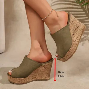 Detailed side view of olive green suede wedge mules with 10cm cork platform