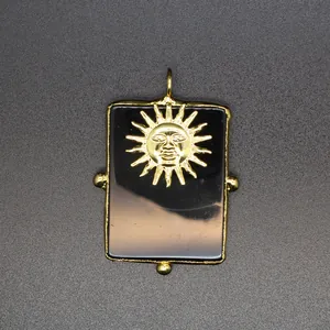 Vue détaillée d'un pendentif en agate noire avec un motif de visage de soleil doré