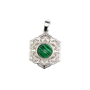 Gros plan d'un pendentif argenté avec pierre de malachite et cadre en filigrane