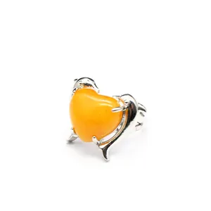 Dettaglio di un anello in argento con doppio delfino e pietra naturale arancione a cuore
