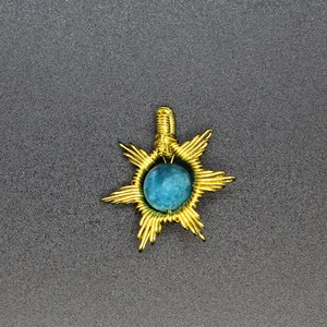 Detailed macro view of a handmade sun-shaped wire-wrapped pendant with blue natural stone.