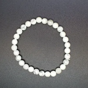 Macro view of 6mm white natural stone beads with marble texture on an elastic bracelet