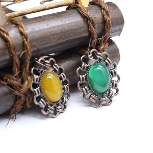 Nahaufnahme von Vintage-Anhängern mit gelben und grünen ovalen Natursteinen in Bronze-Optik