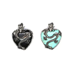 Dettaglio di due ciondoli a cuore con drago e pietre di colore nero e turchese