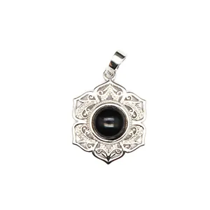 Vue macro d'un pendentif en dentelle florale argentée avec centre en perle de cristal noir