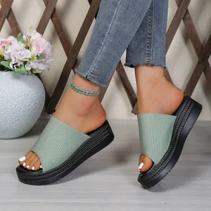 Detailed macro view showing green ribbed fabric uppers and thick black platform wedge soles