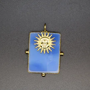 Vue détaillée de l'emblème du soleil d'or sur un pendentif rectangulaire en agate bleue