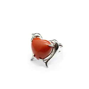 Dettaglio dell'anello in argento con doppio delfino e pietra naturale rossa a forma di cuore