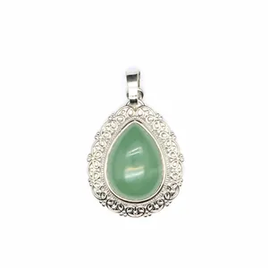 Close-up view of a green teardrop stone pendant with ornate silver filigree lace