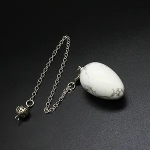 Detailed view of a white howlite egg-shaped dowsing pendulum with silver chain.