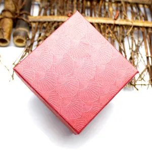 Macro view of a red jewelry gift box featuring a textured shell pattern on the surface