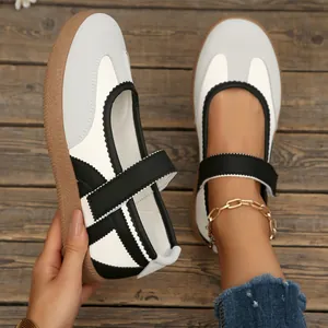 Vista dettagliata delle scarpe Mary Jane German Trainer bianche con velcro su legno