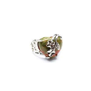 Close-up of heart-shaped unakite ring with delicate silver flower accents
