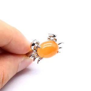 Detaillierte Nahaufnahme eines einzigartigen orangefarbenen Opal-Krabbenrings in Silberoptik