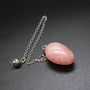 Detailed view of the natural pink stone egg pendulum with its delicate silver chain.