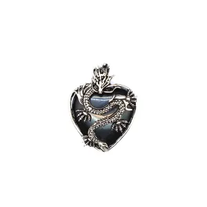 Dettaglio di un pendente a cuore nero con drago d'argento e decorazioni intricate