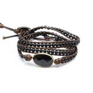Close-up of a multi-layer wrap bracelet featuring black onyx beads and a faceted center stone