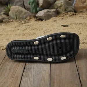 Dettaglio della suola in gomma nera antiscivolo di un sandalo da spiaggia estivo da donna.