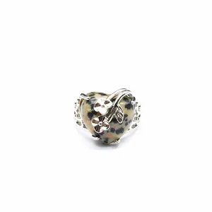 Detailed close-up of heart-shaped Dalmatian Jasper ring featuring a silver flower design